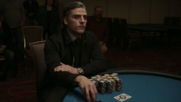 A gambler covets his stacks of chips at a card table.