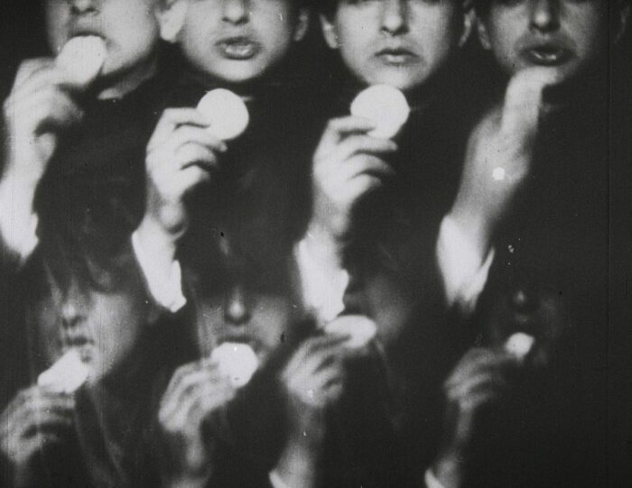 Still from the 1932 short film Europa as exhibited at the Tate gallery: rows of faces consuming slices of apple