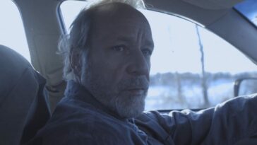 Andrew Bee as Monette driving his car in Mute