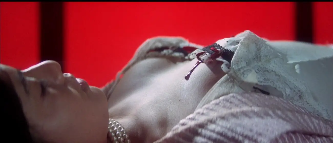 Image from Tokyo Drifter: A dead woman is shown in close-up with blood on her breast.