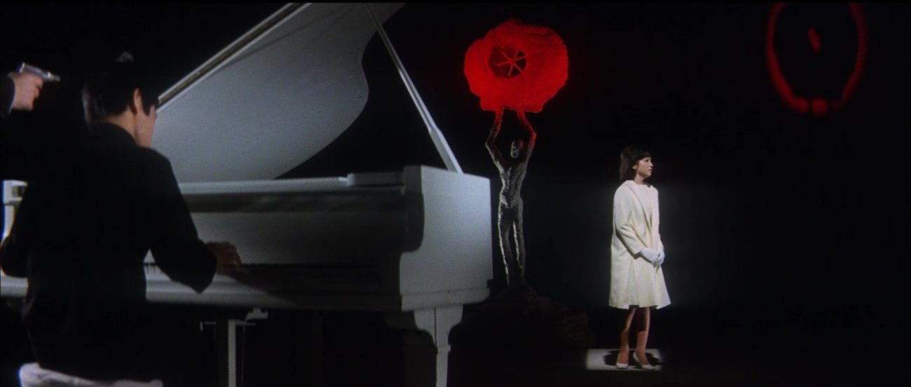 Image from Tokyo Drifter: Chiharu sings as an unseen assailant holds a pistol to her piano player's head.