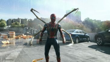 Spider-Man standing on a bridge with debris behind him