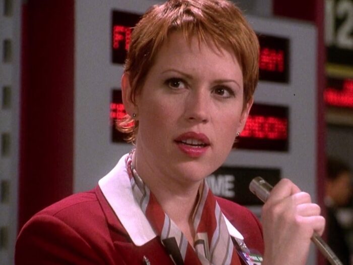 Molly Ringwald's character from Not Another Teen Movie, holding a flight attendant's microphone