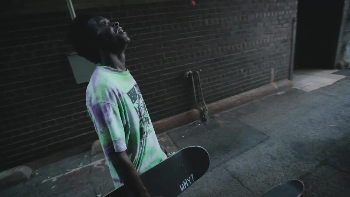 Image from Minding the Gap: Keire Johnson, holding a skateboard, looks up off camera