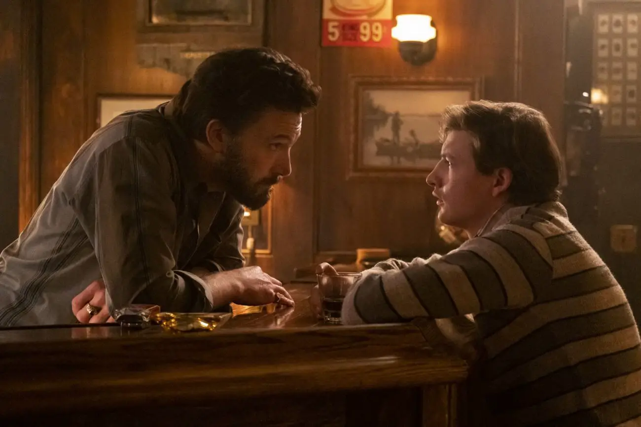 A man and his nephew talk at a bar.