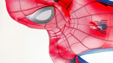 A costumed Spider-Man lays against a white background in close-up.