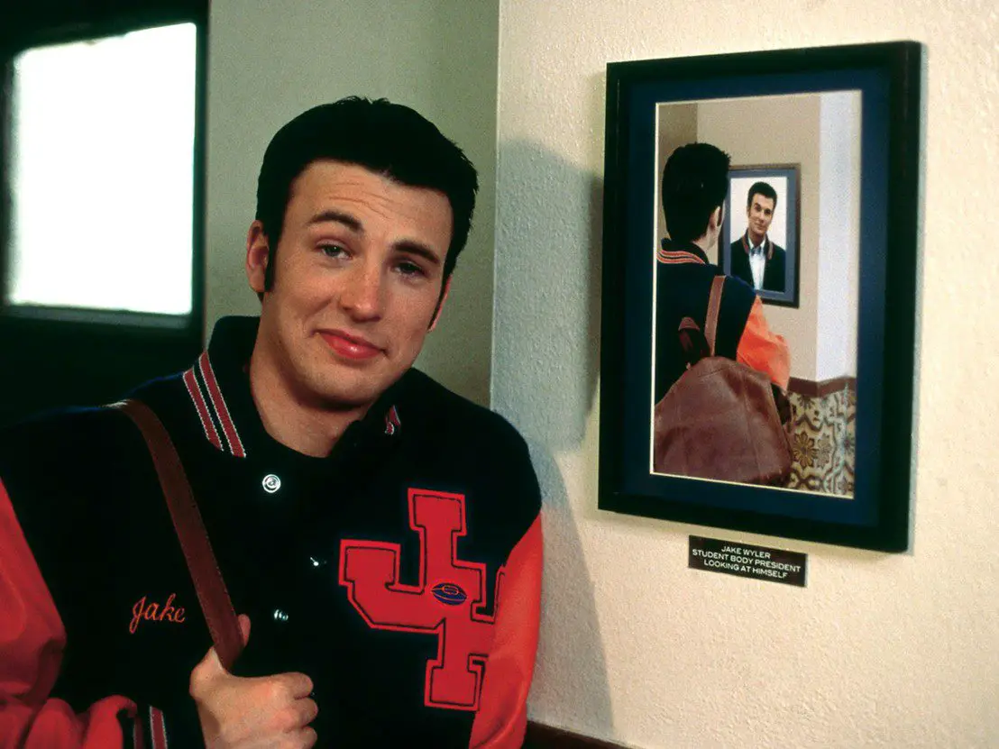 Chris Evans' character from Not Another Teen Movie, standing in front of a portrait of himself looking at a portrait of himself