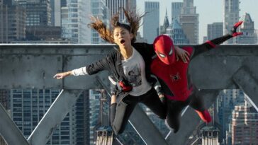 MJ (Zendaya) and Peter (Tom Holland) make a leap from a rooftop scaffolding in the opening scene of No Way Home