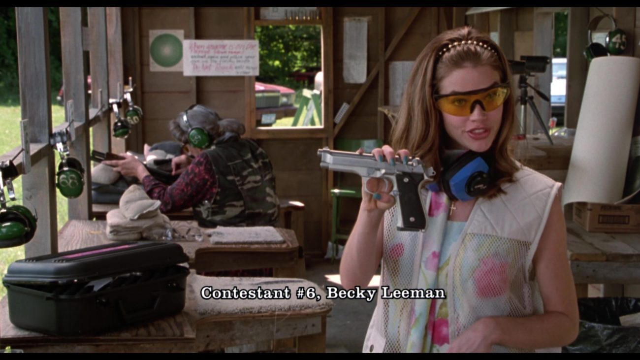 Denise Richards as Becky Ann Leeman in Drop Dead Gorgeous, holding a pistol at a gun range.