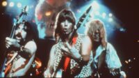 Derek, Nigel and David of mock-rock band Spinal Tap wield their guitars like weapons and turn the volume up to 11