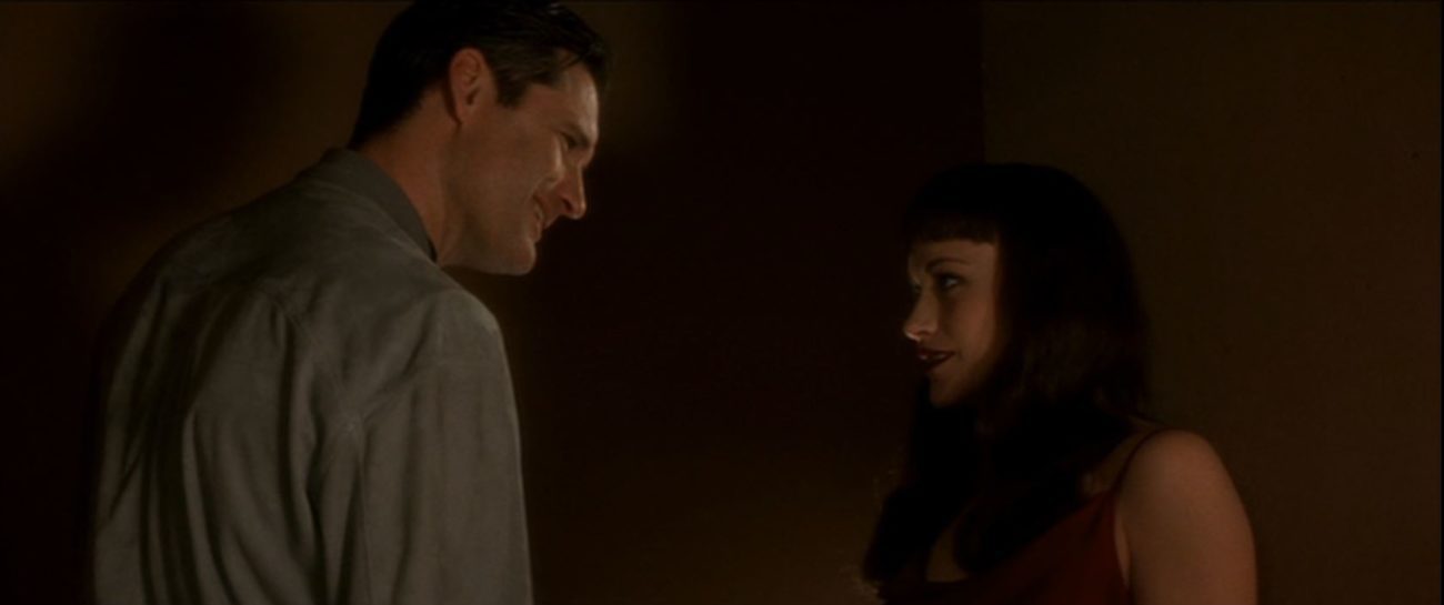 Fred smirks at Renee as they stand in the dark of their house