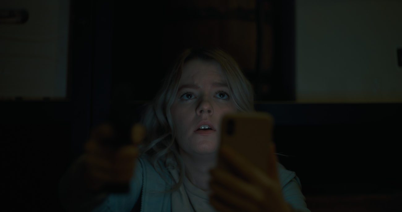 Sophie, brandishing a gun and her phone into camera