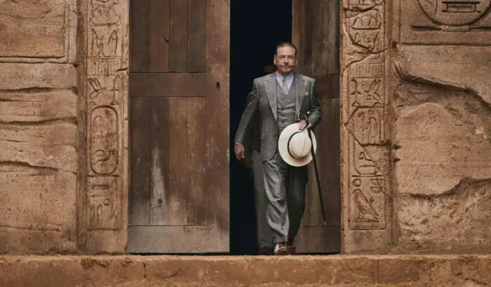 A detective walks out of a temple entrance.