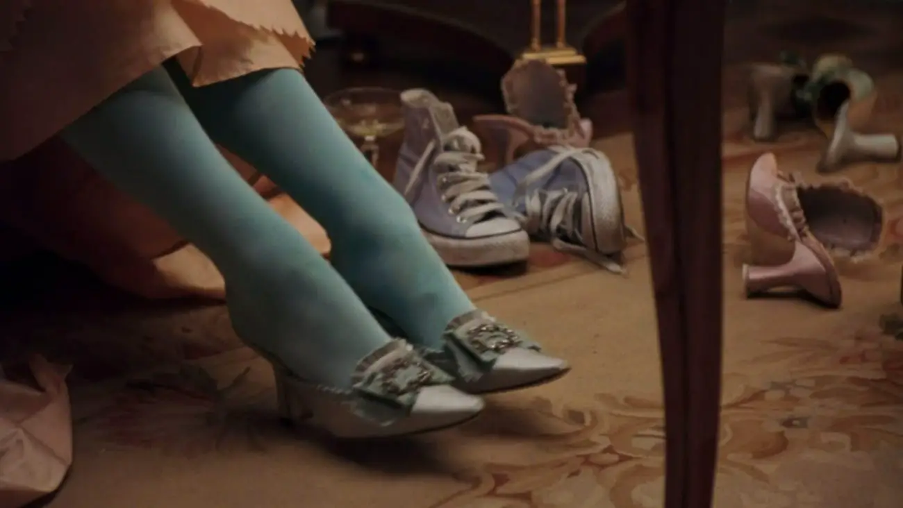 Image from Marie Antoinette: a pair of Converse Chuck Taylor All-Stars are depicted alongside other foortwear at the Palace of Versailles.