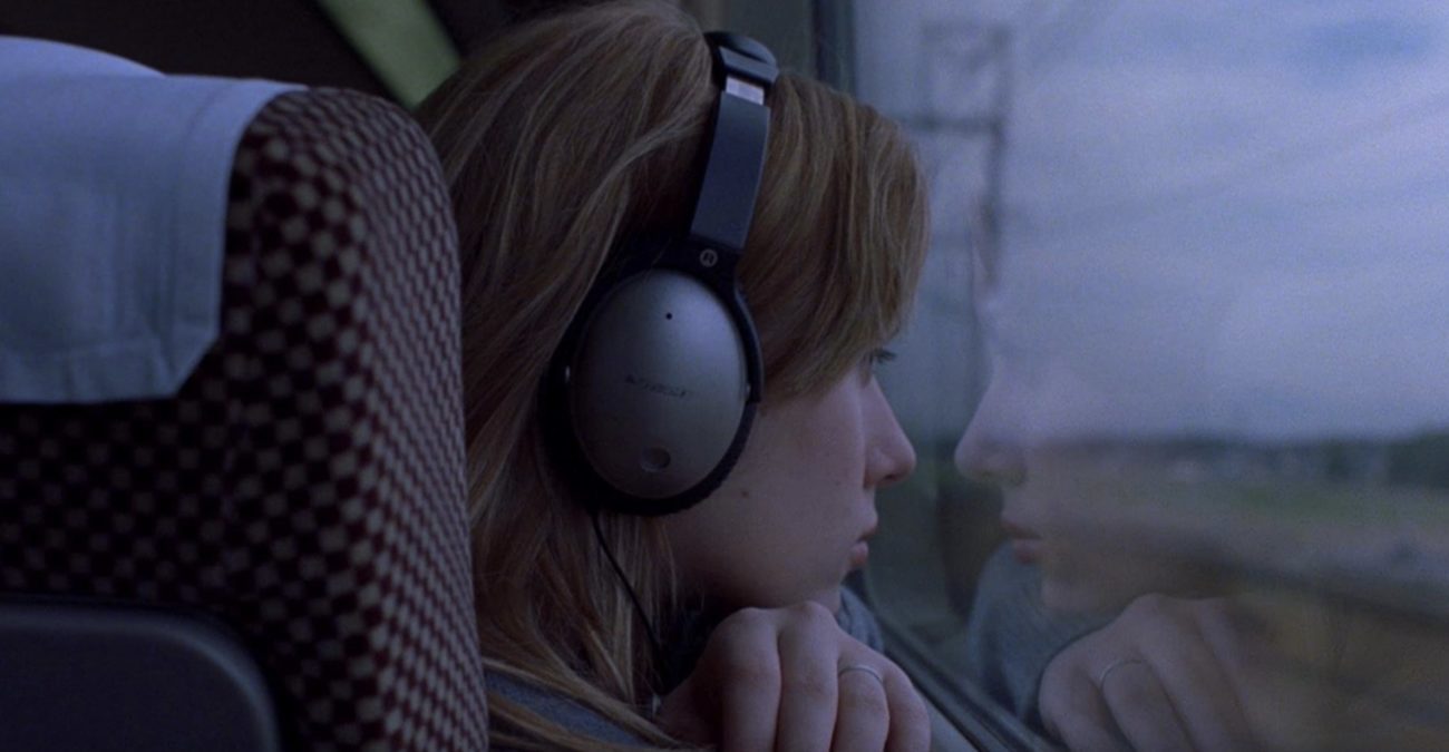 Charlotte with headphones on train in Lost In Translation