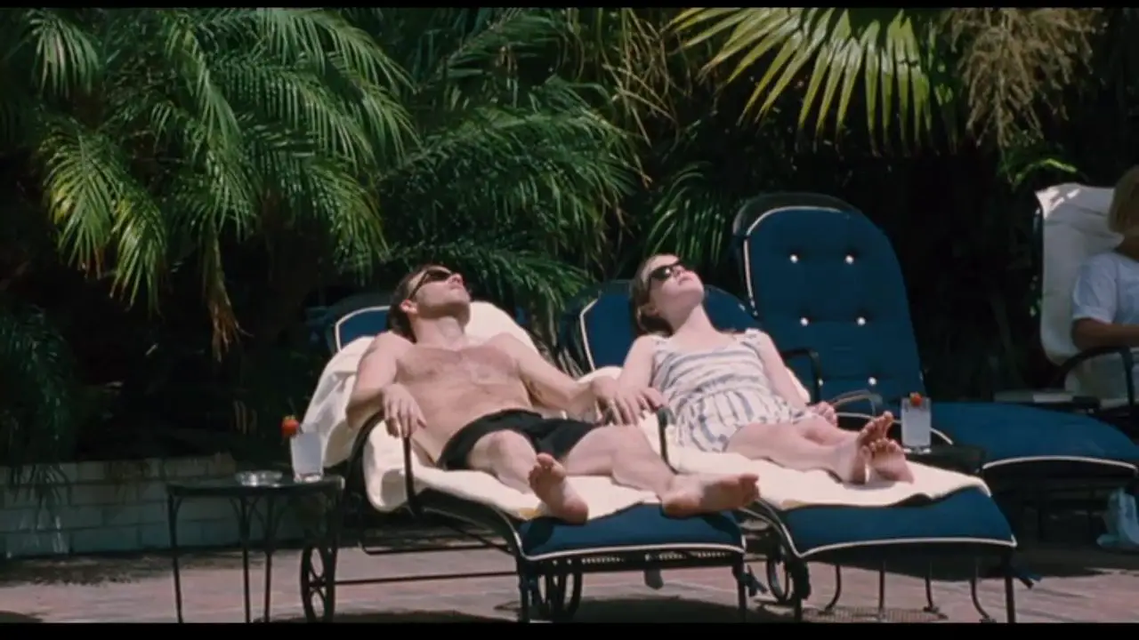Image from Somewhere: Johnny and Cleo sit together at poolside.