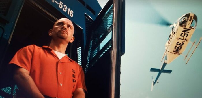 John Malkovich in an orange prison jumpsuit portraying Cyrus the Virus in Con Air