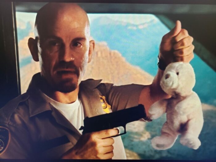 Cyrus the Virus points a pistol at a stuffed bunny