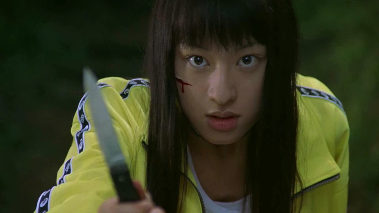 A female holding a knife with a cut on her face.