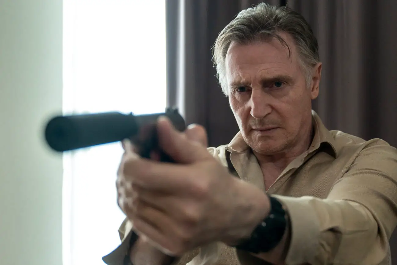 Alex Lewis (Liam Neeson) points a gun in Memory.