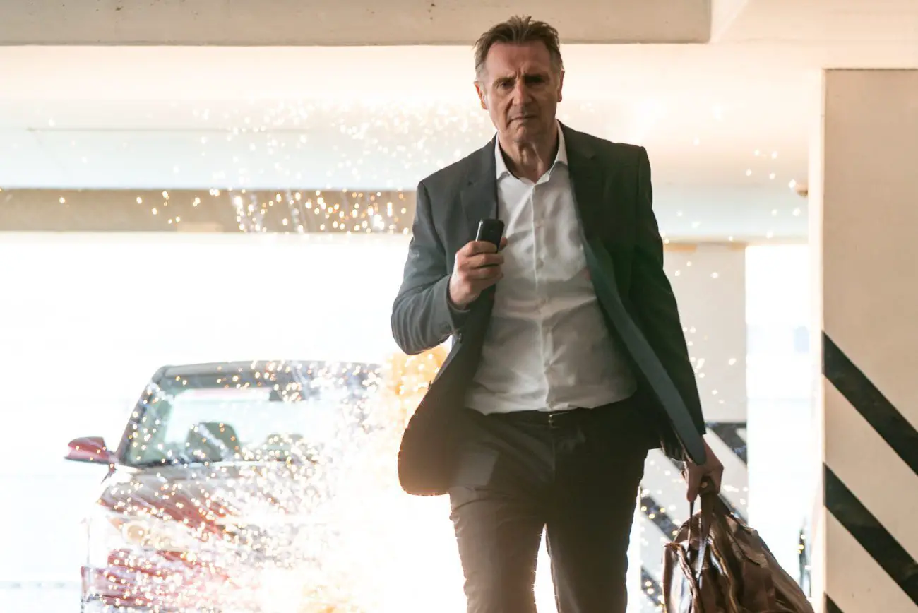 Liam Neeson as Lex Lewis walks away from an exploding car.