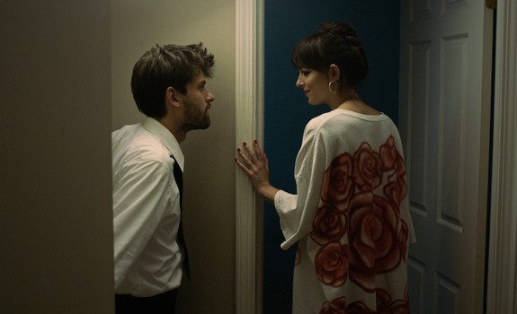 Man and woman look at each other in a doorway