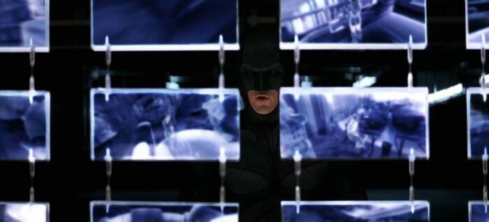 Batman, mostly hidden behind a wall of screens