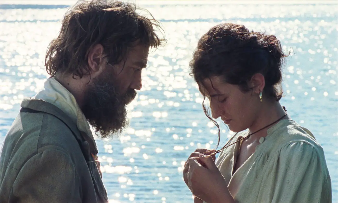 Luciano (Gabriele Silli) and Emma (Maria Alexandra Lungu) converse in front of a lake.