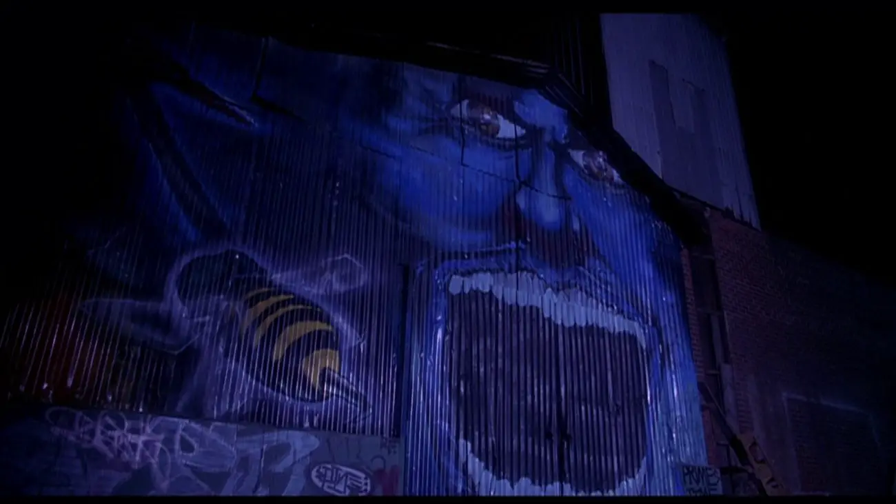 Exterior building with graffiti of Candyman and a bee.