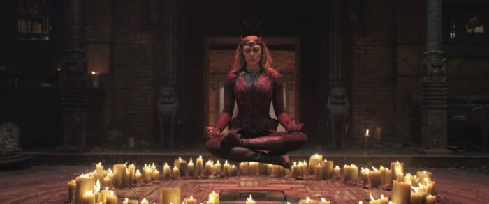 A powerful woman levitates above a circle of candles.