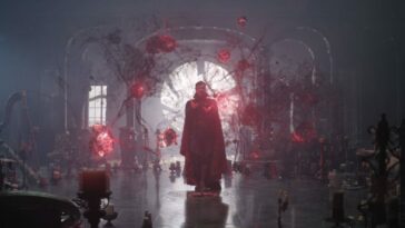 Magical red tendrils surround a man in a cape.