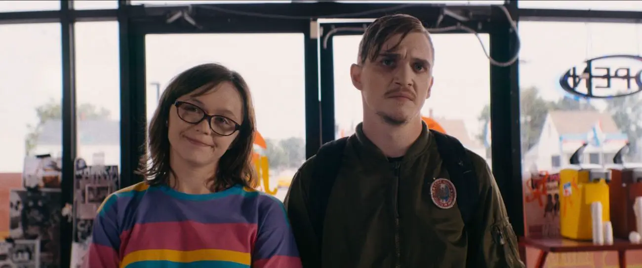 Patty (Emily Skeggs) and Simon (Kyle Gallner) stare at the camera in a fast-food restaurant.