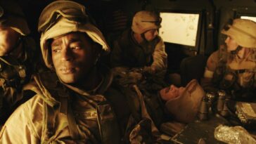 Four soldiers are seen riding in a Humvee.