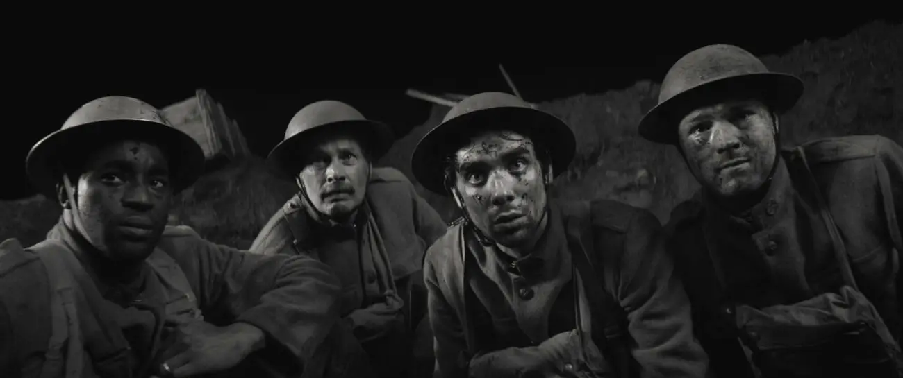 Four soldiers gaze in fear towards the dark battlefield.