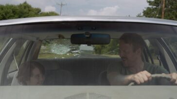 Cooper J. Friedman as Tyler and David Sullivan as Wayne in a car with a broken rear window.