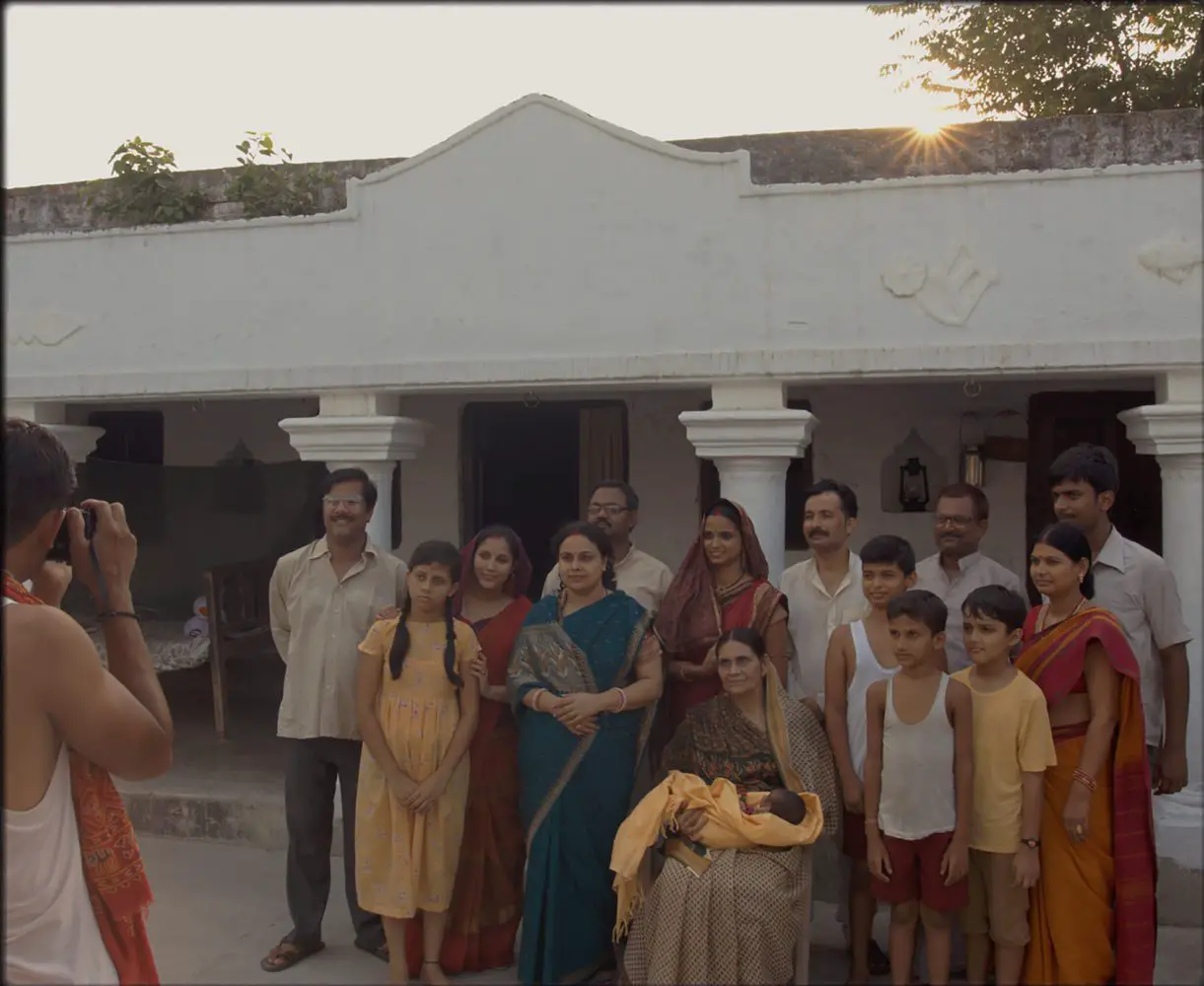 An Indian family poses for a picture in front of their house