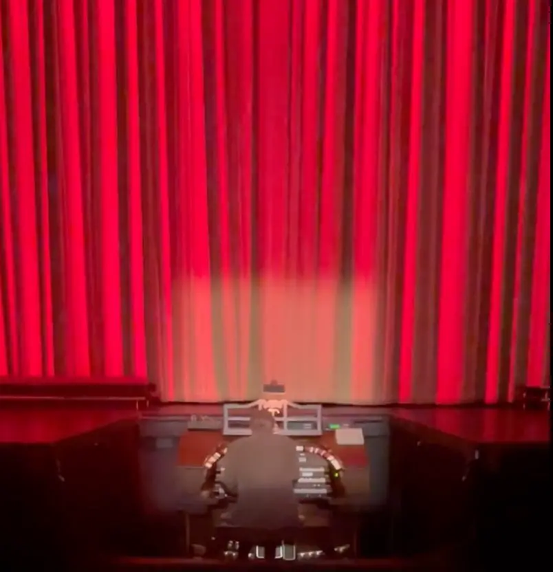 red curtains and person playing organ