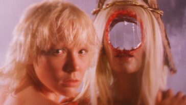 A blonde woman appears next to a second blond woman with a large hole in her head