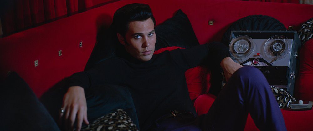 A man looks up from his lounge couch dressed in black.