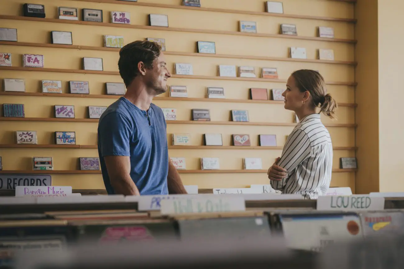 A man and woman talk in the aisles of a record sore.