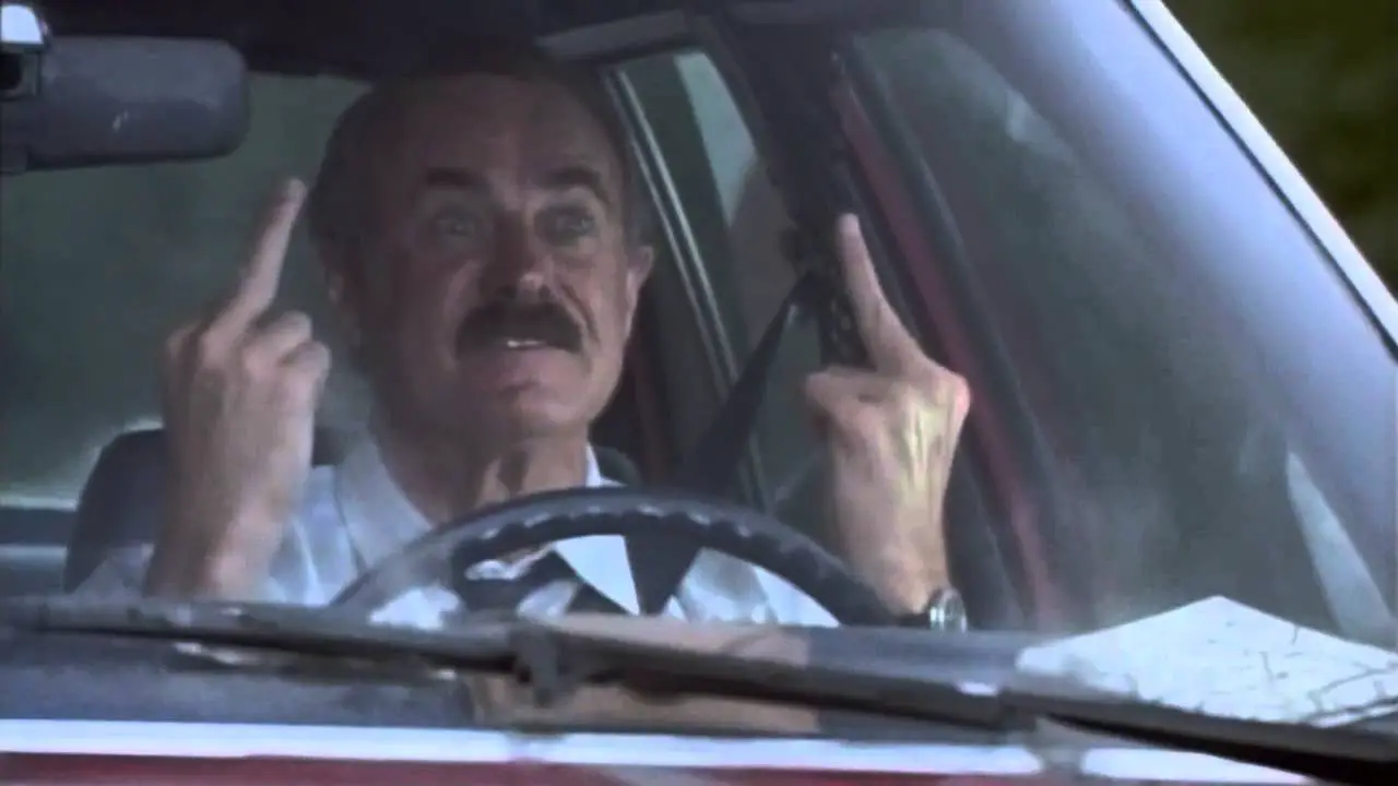 Burt driving while giving two middle fingers