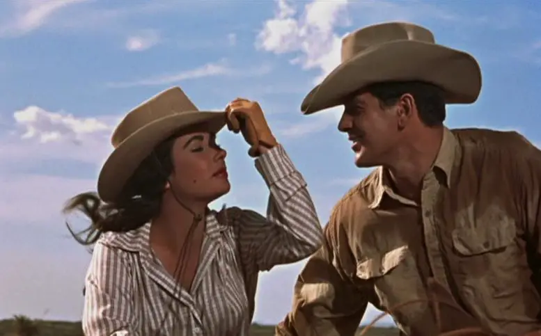 A woman tips her hat towards a man outdoors.