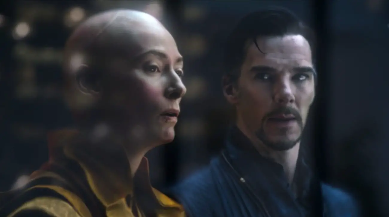 The translucent forms of the Ancient One (Tilda Swinton) and Stephen Strange standing in front of a building, her looking outward and him looking at her