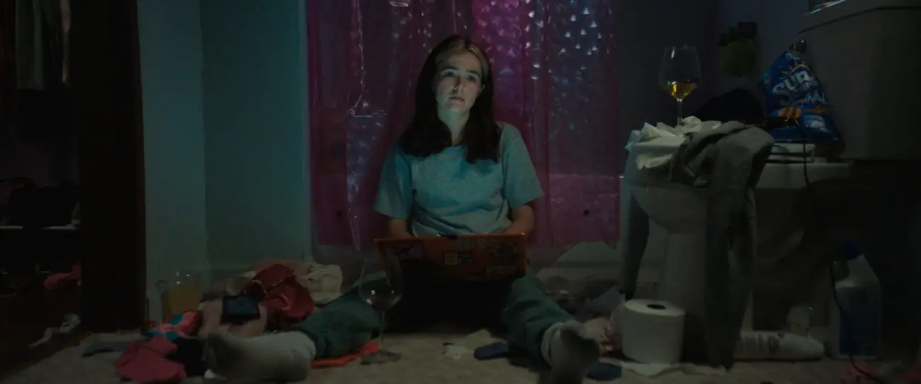Danni on the floor of her bathroom, laptop in front of her