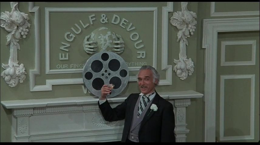 Silent Movie: Harold Gould as "Engulf" in front of the company motto, "Our Fingers are in Everything"