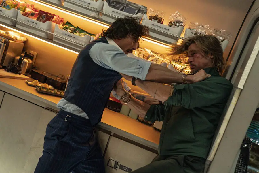Tangerine (Aaron Taylor-Johnson) chokes Ladybug (Brad Pitt) in the snack car of the bullet train.