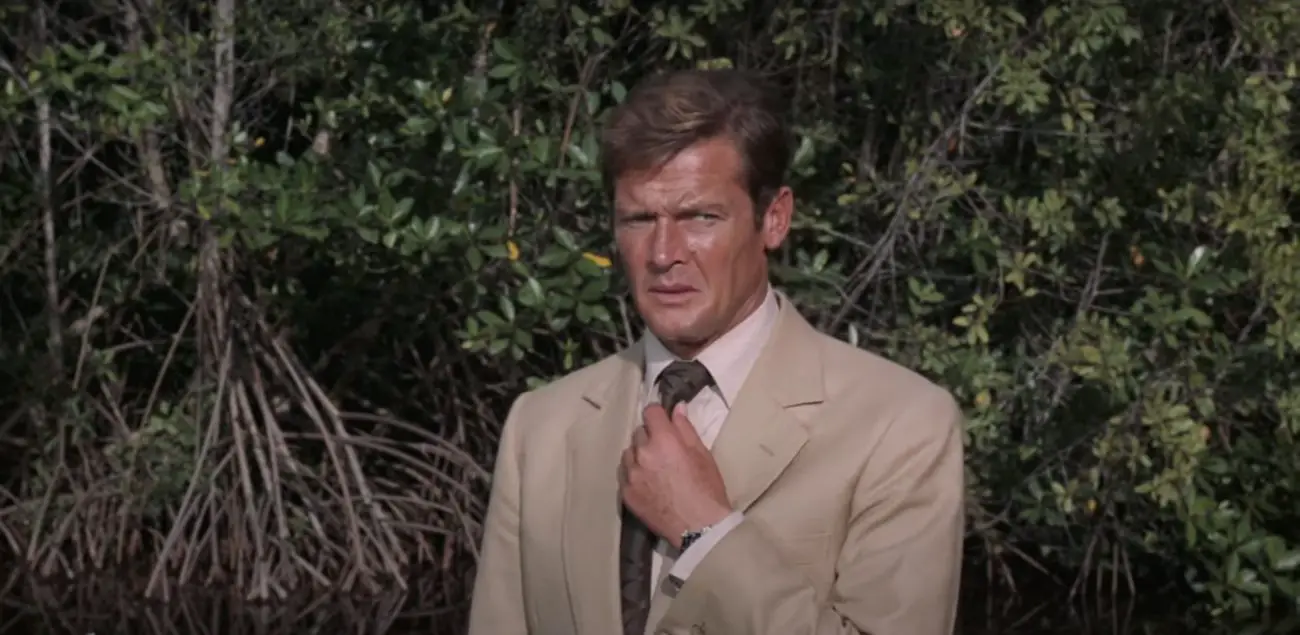 Roger Moore nervously straightening his tie in Live and Let Die (1973)