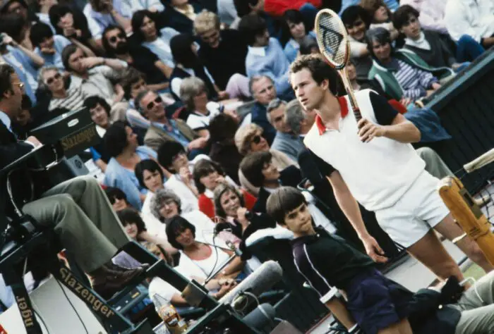 John McEnroe (USA) by the net talking to the Umpire in a tennis match.