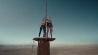 Two women stand atop a small platform on an antenna