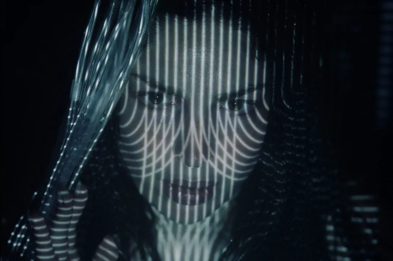 From Tin Can: Anna Hopkins as Fret, a pattern of light projected on her face.